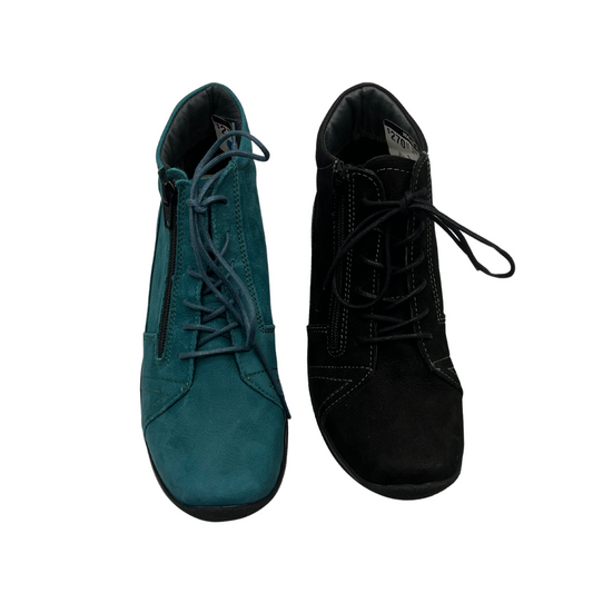 Top view of two lace up short boots side by side. One is teal suede and the other is black suede. Both have matching laces and a rounded toe.
