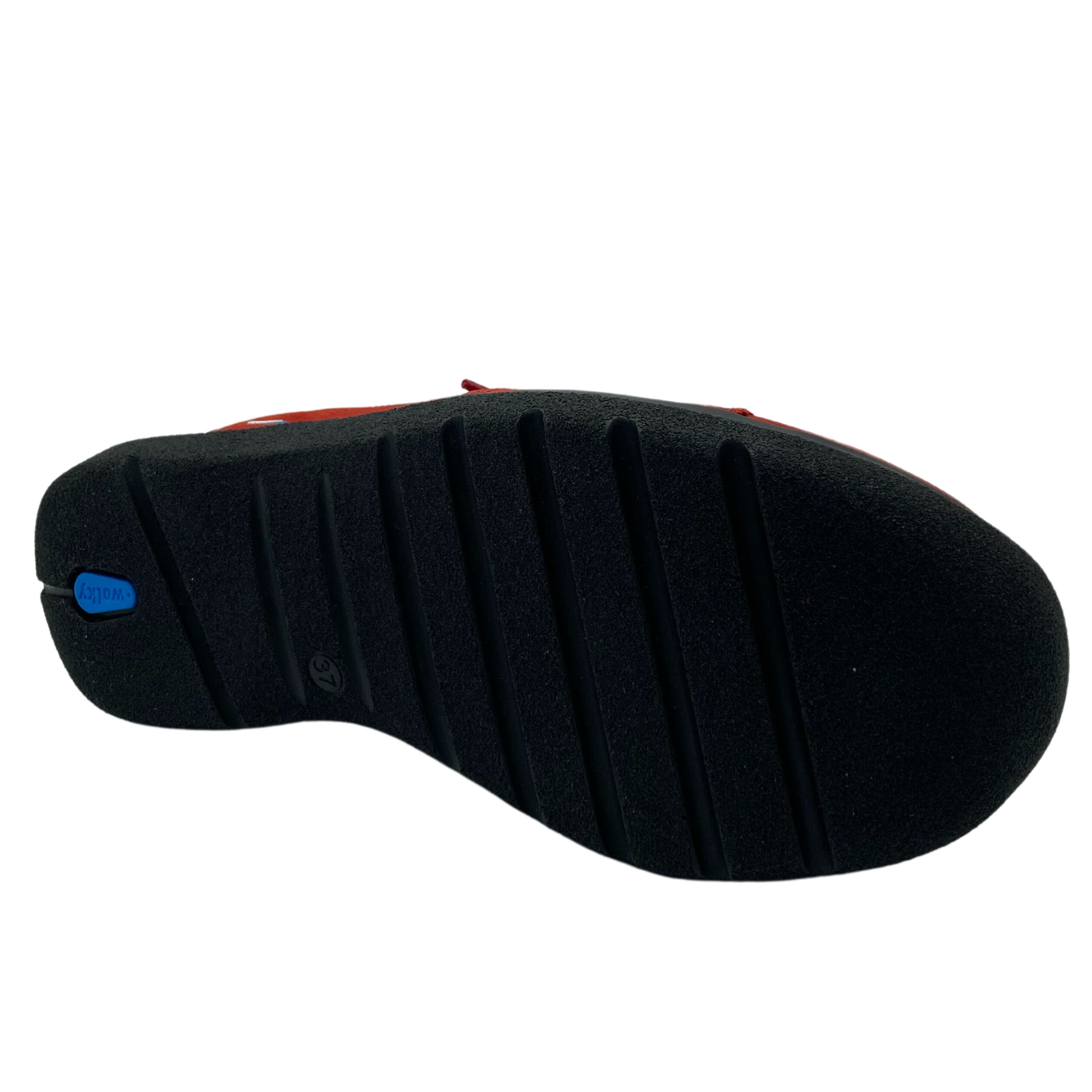 Bottom view of red leather sneaker with black rubber sole
