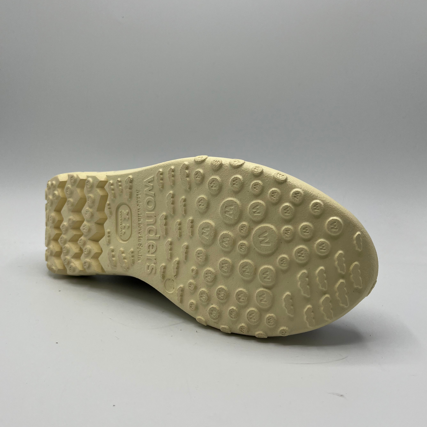 Beige shoe sole with tread pattern on a gray background