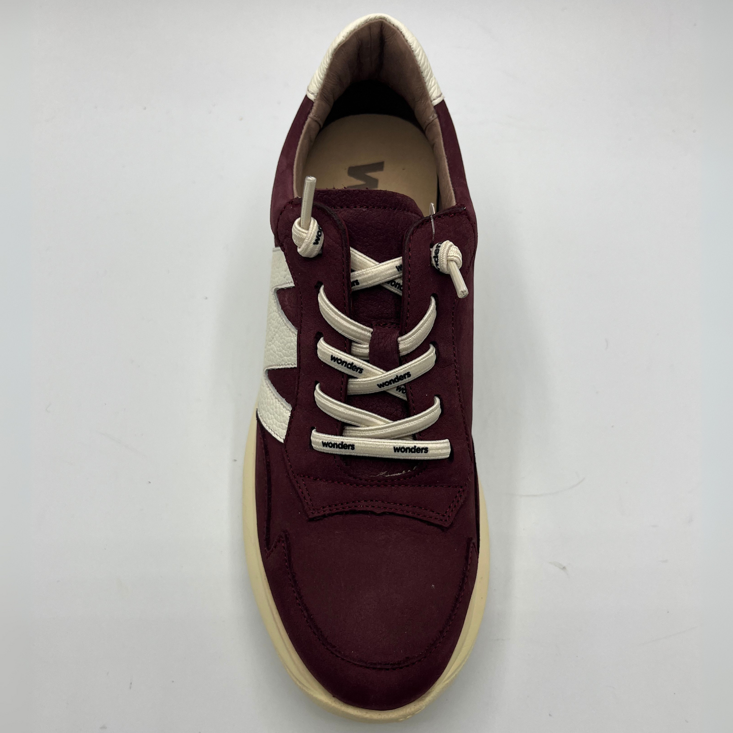Maroon sneaker with white laces on a light gray background