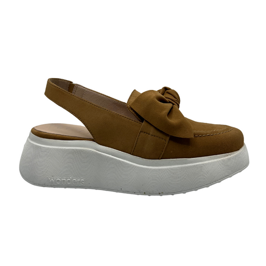 Right facing view of tan suede shoe with an elasticated sling back strap, thick white rubber outsole and knotted bow detail on the vamp.