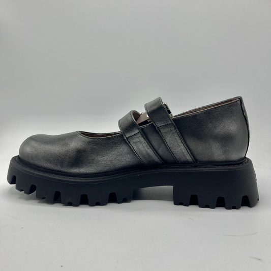 Black leather shoe with thick sole on a light gray background