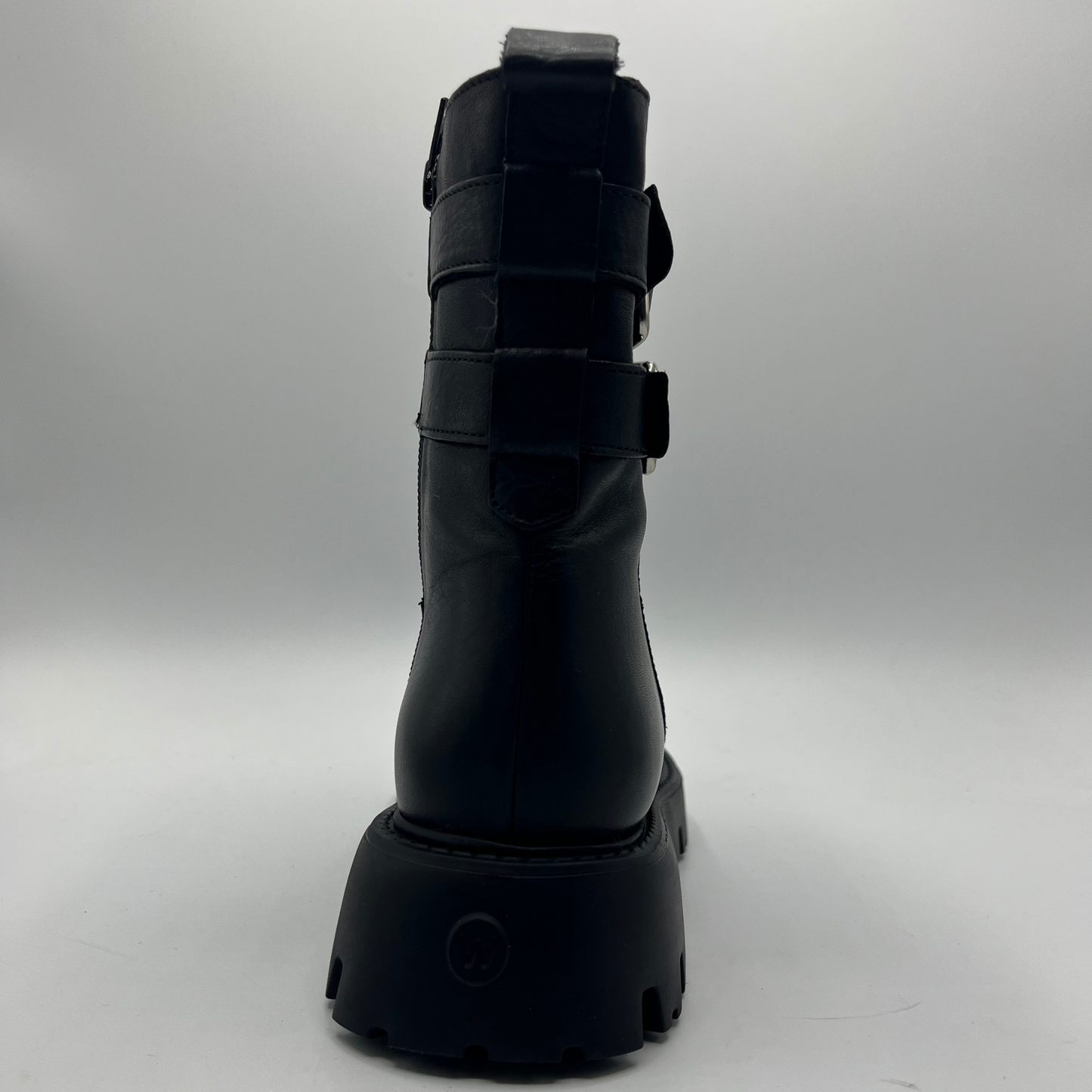 Black boot with multiple straps on a gray background