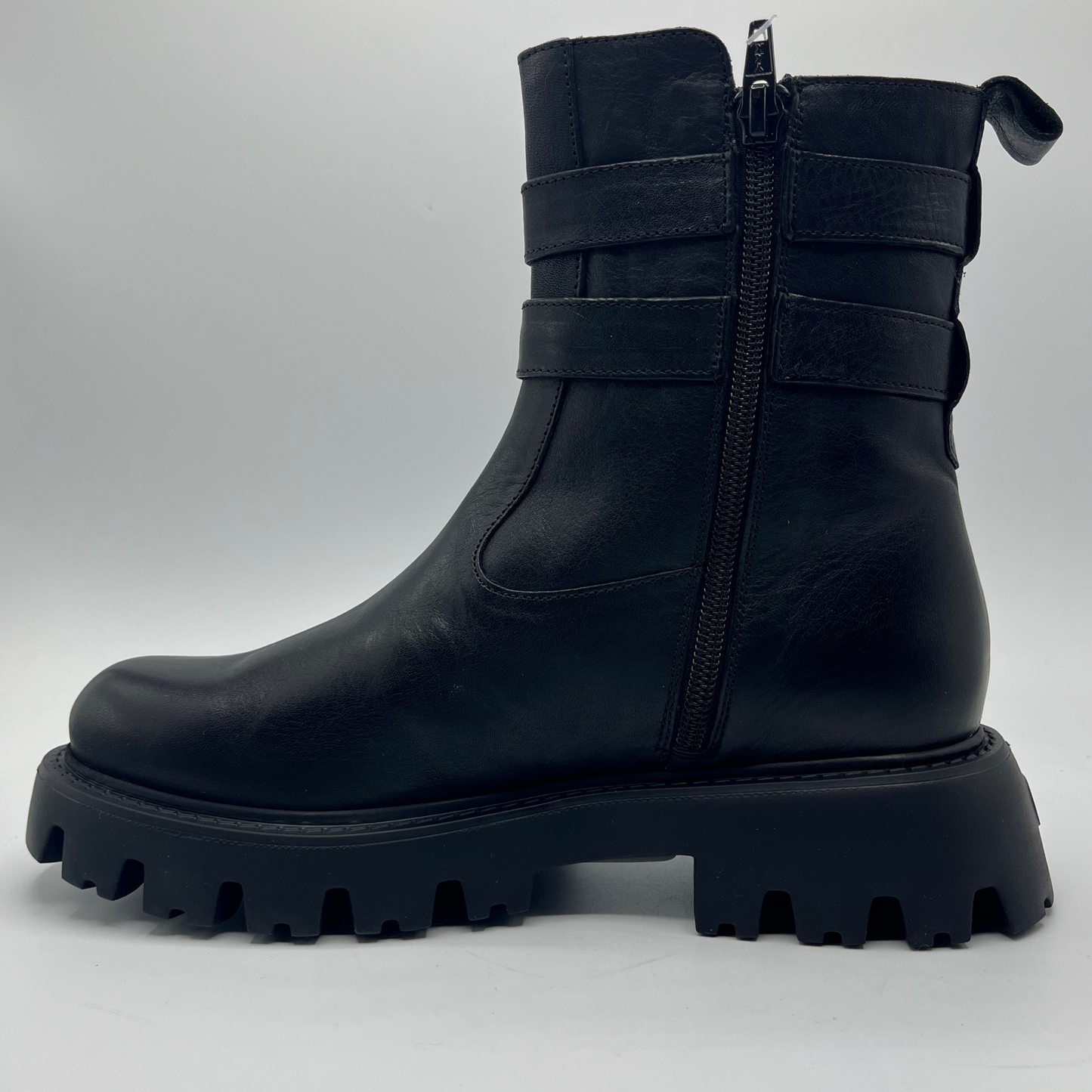 Black boot with chunky sole on a light gray background