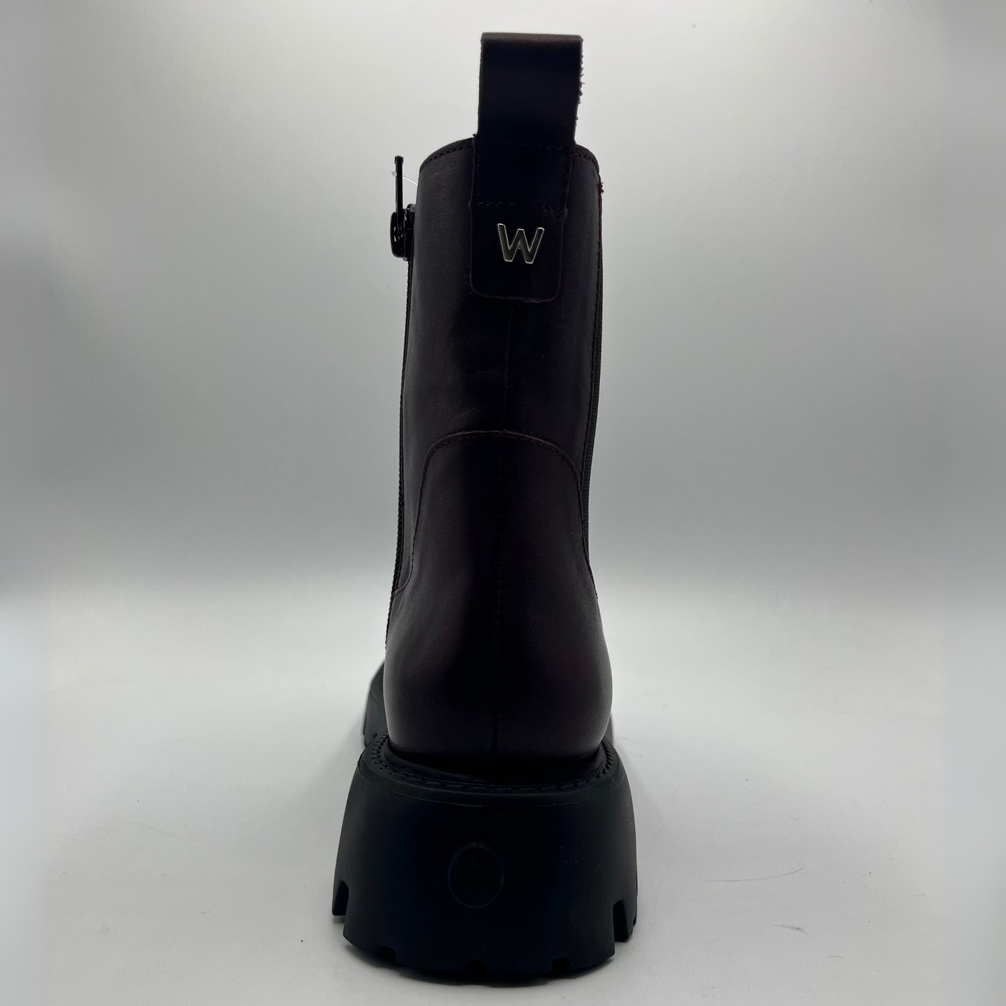 Wine coloured leather boot on a gray background
