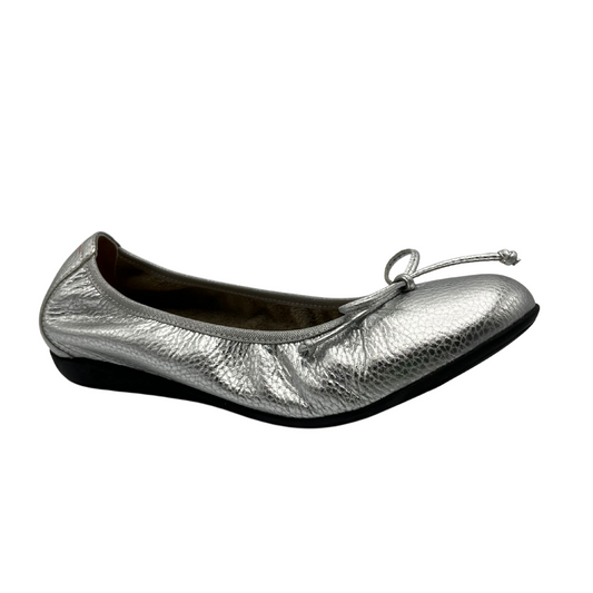 Angled view of silver leather ballet flat with a flexible black outsole and matching lace up bow on the toe box.