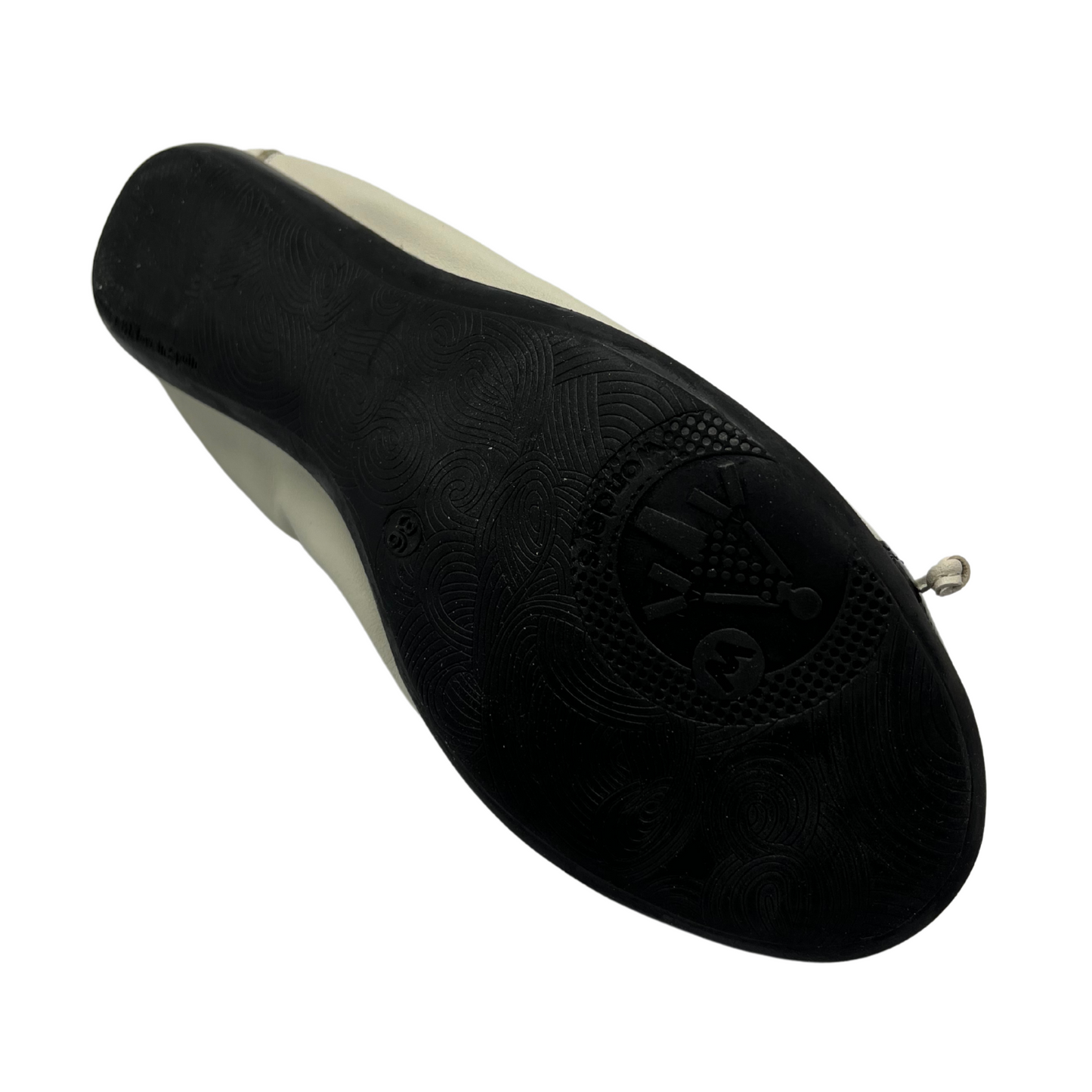 Bottom view of off white and black leather ballet flat. It has a Flexible outsole and a delicate bow on the toe.