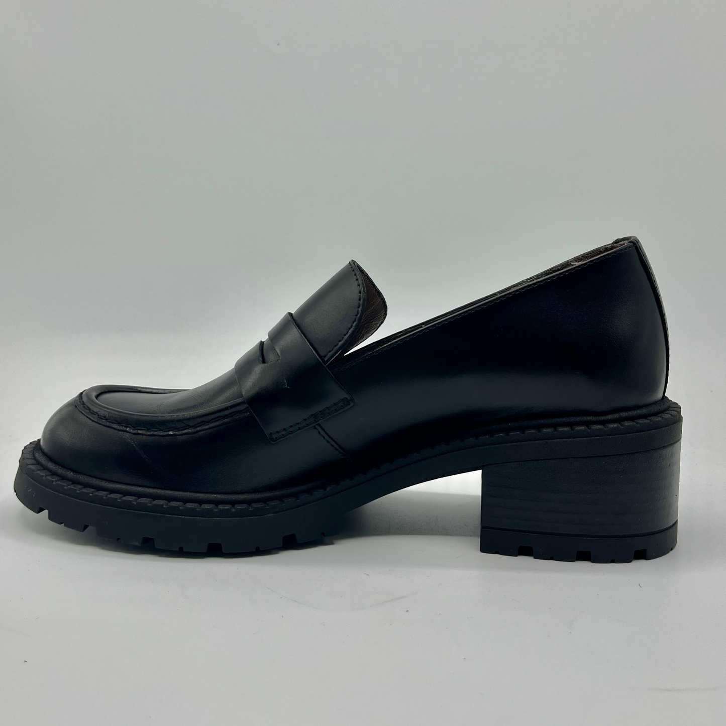 Black leather loafer shoe on a light gray background