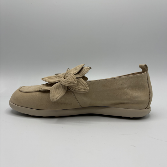 Beige loafer shoe with a decorative bow on a white background