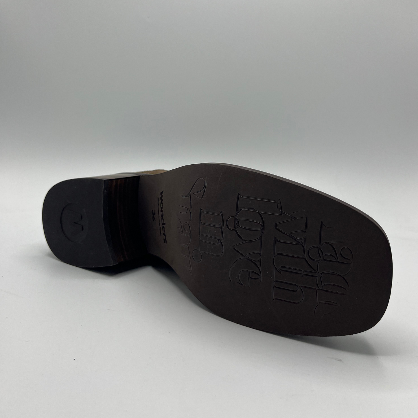 Brown shoe sole with brand logo on a gray background