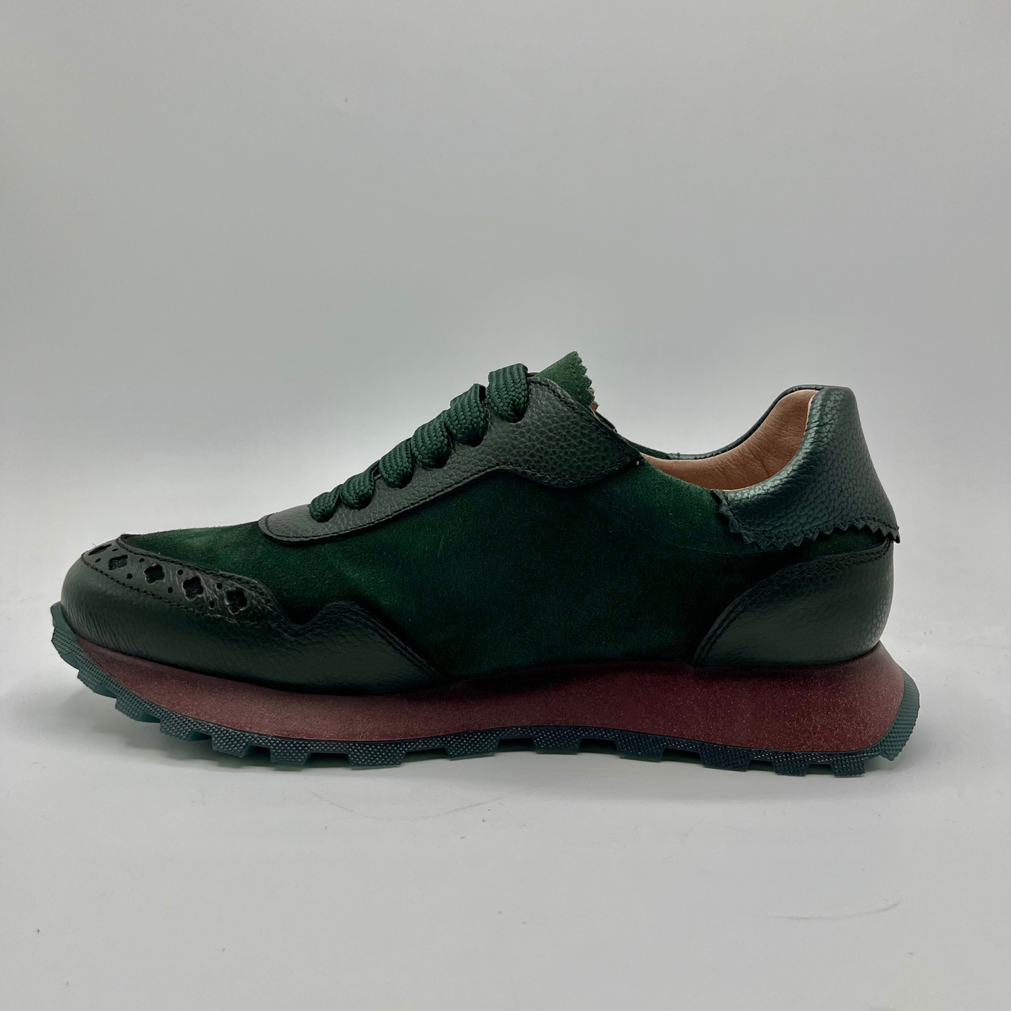 Green sneaker with brown sole on a white background