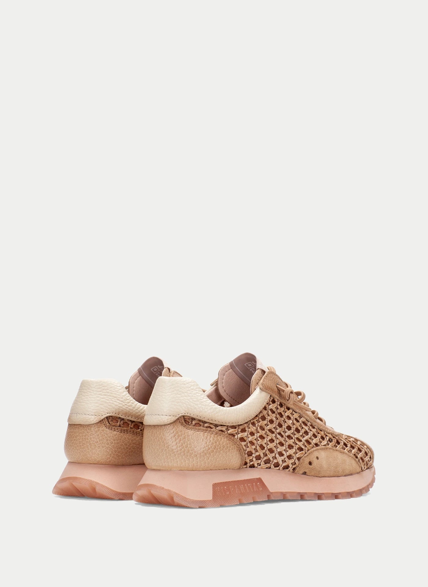 Pair of beige and brown sneakers on a light gray background