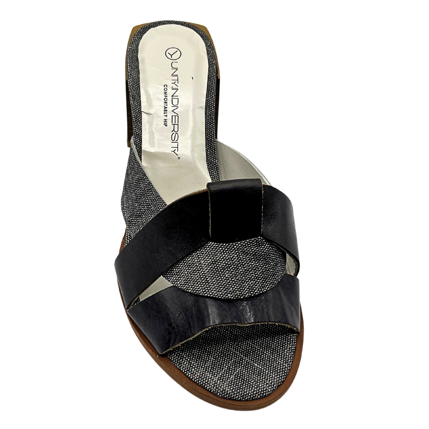 Top down view of a mule sandal with open toe. Smooth black leather is combined with patterned black/white