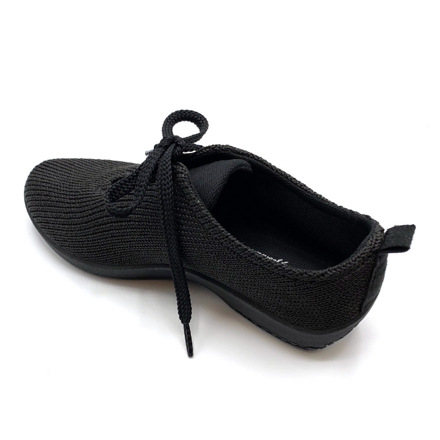 Back angle view of black knit sneaker with back tab and shoestrings visible.