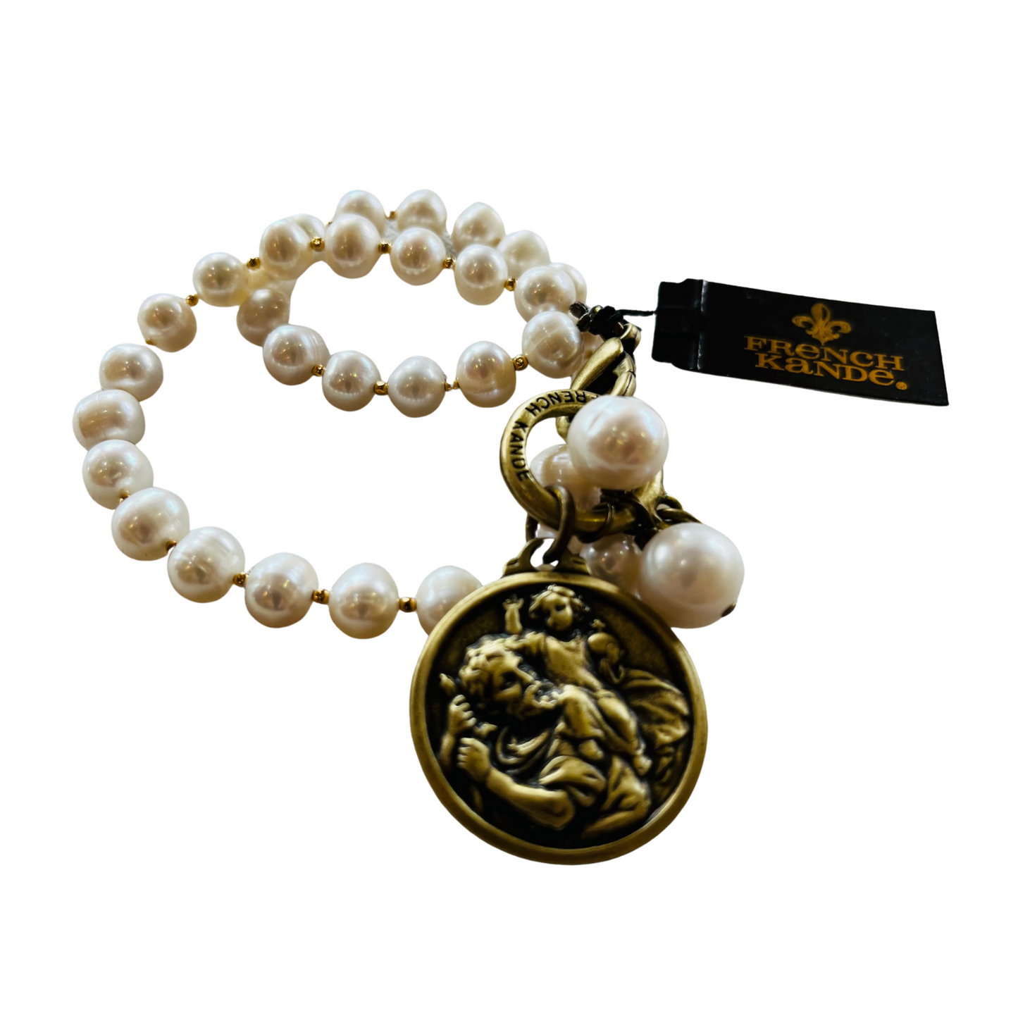 Image depicts a beautiful white pearl bracelet with an antique brass clasp and a gold St. Christopher medallion attached.