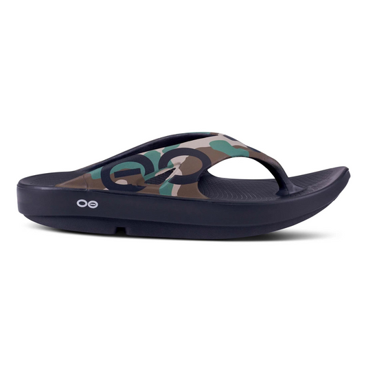 Black soled flip-flop with thick arched toe and camo-print upper pictured in profile.