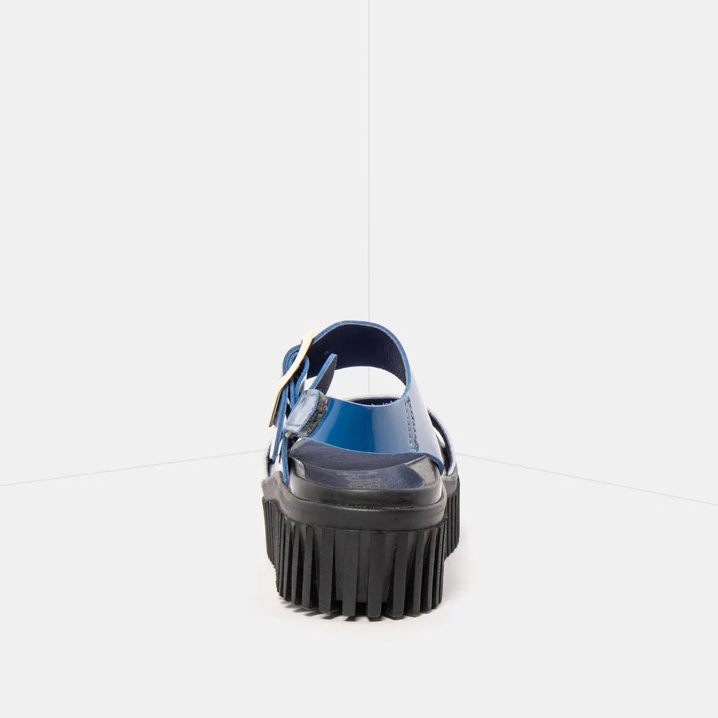 Blue sandal with a thick black sole on a white background