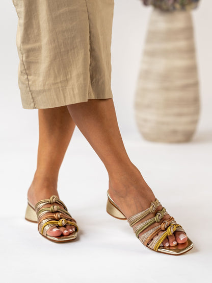 Person wearing strappy sandals with a neutral background