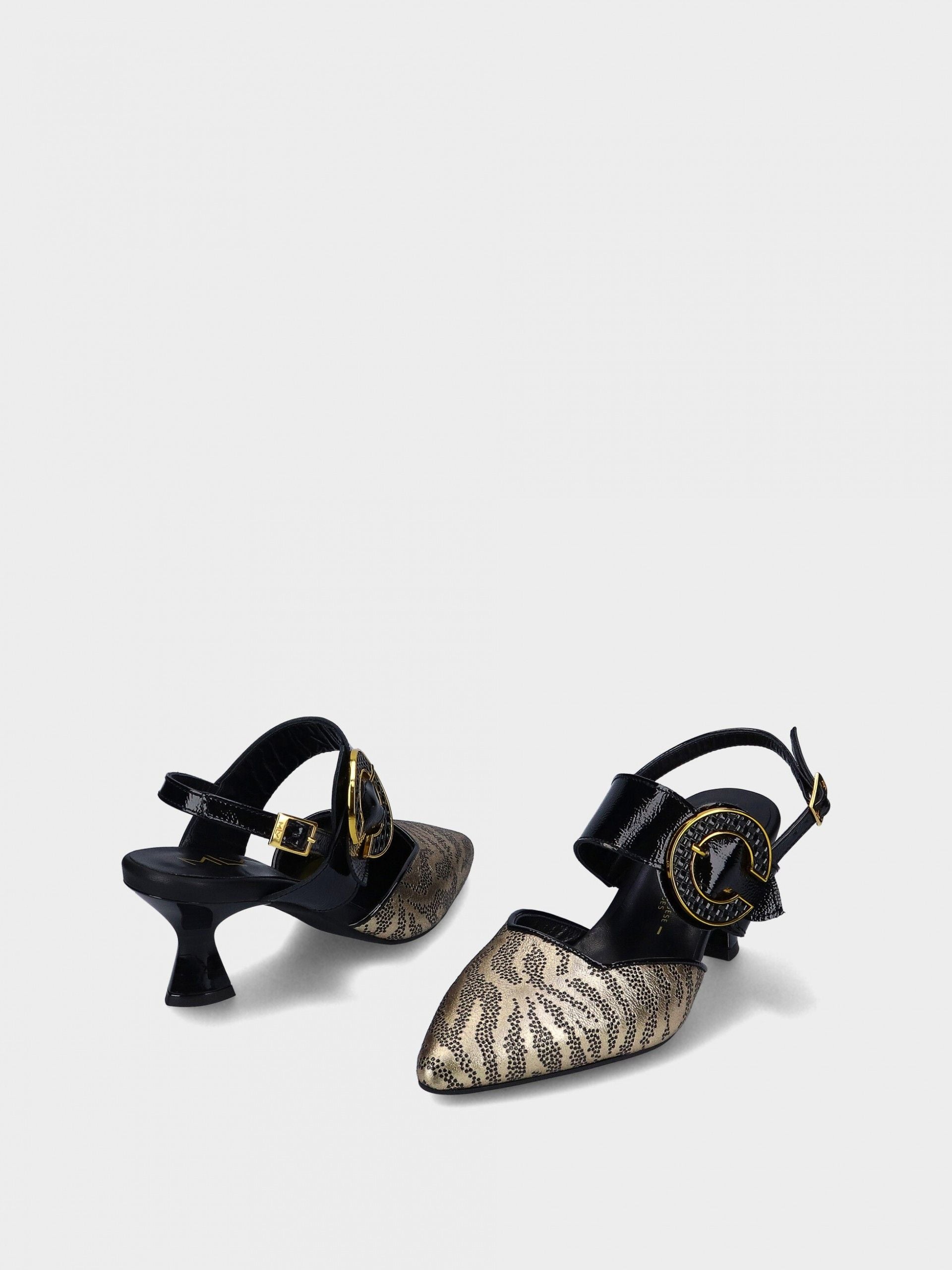 Pair of black and gold high-heeled shoes on a light gray background
