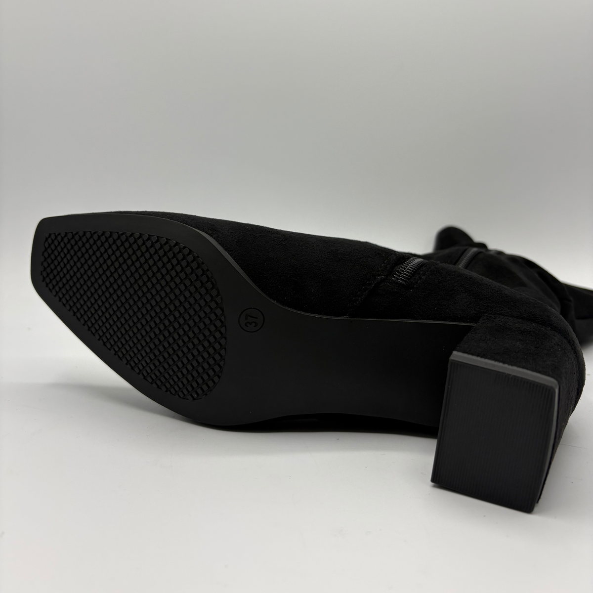 Bottom view of a black slouchy boot with a block heel