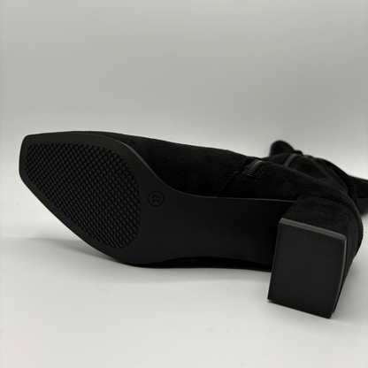 Bottom view of a black slouchy boot with a block heel
