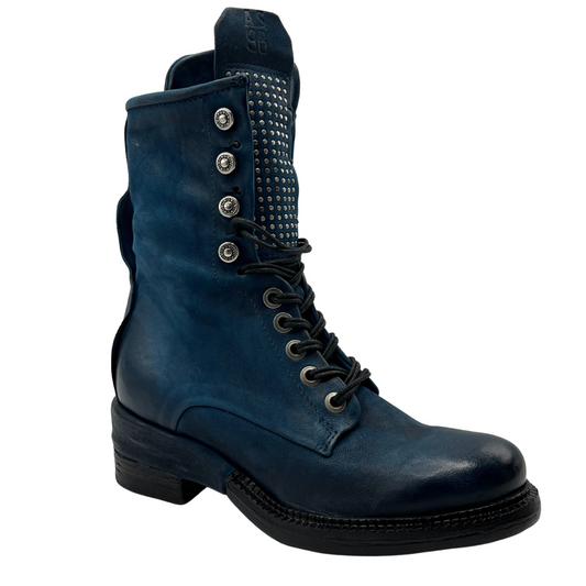 45 degree angled view of blue leather mid-calf boot with black heel and outsole, matching laces and embellishment on upper