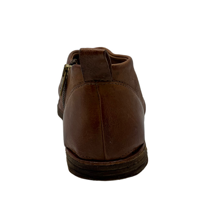 Back view of brown leather shoe with side zipper closure and flat sole