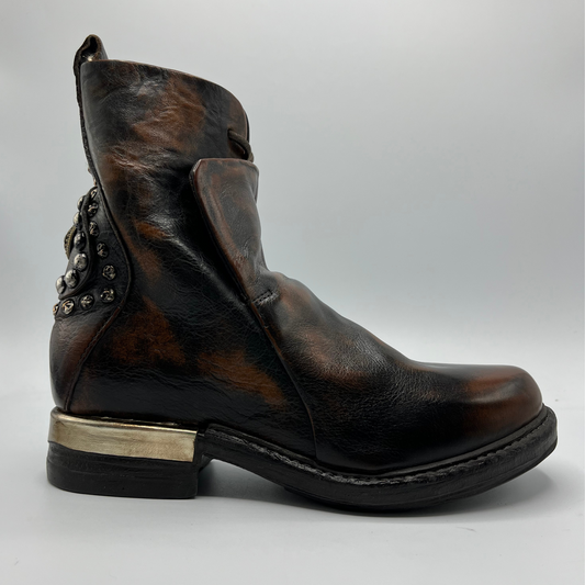 Right facing view of a brown and black burnished short boot with a gold accent on the heel and metallic embellishments along the shaft.