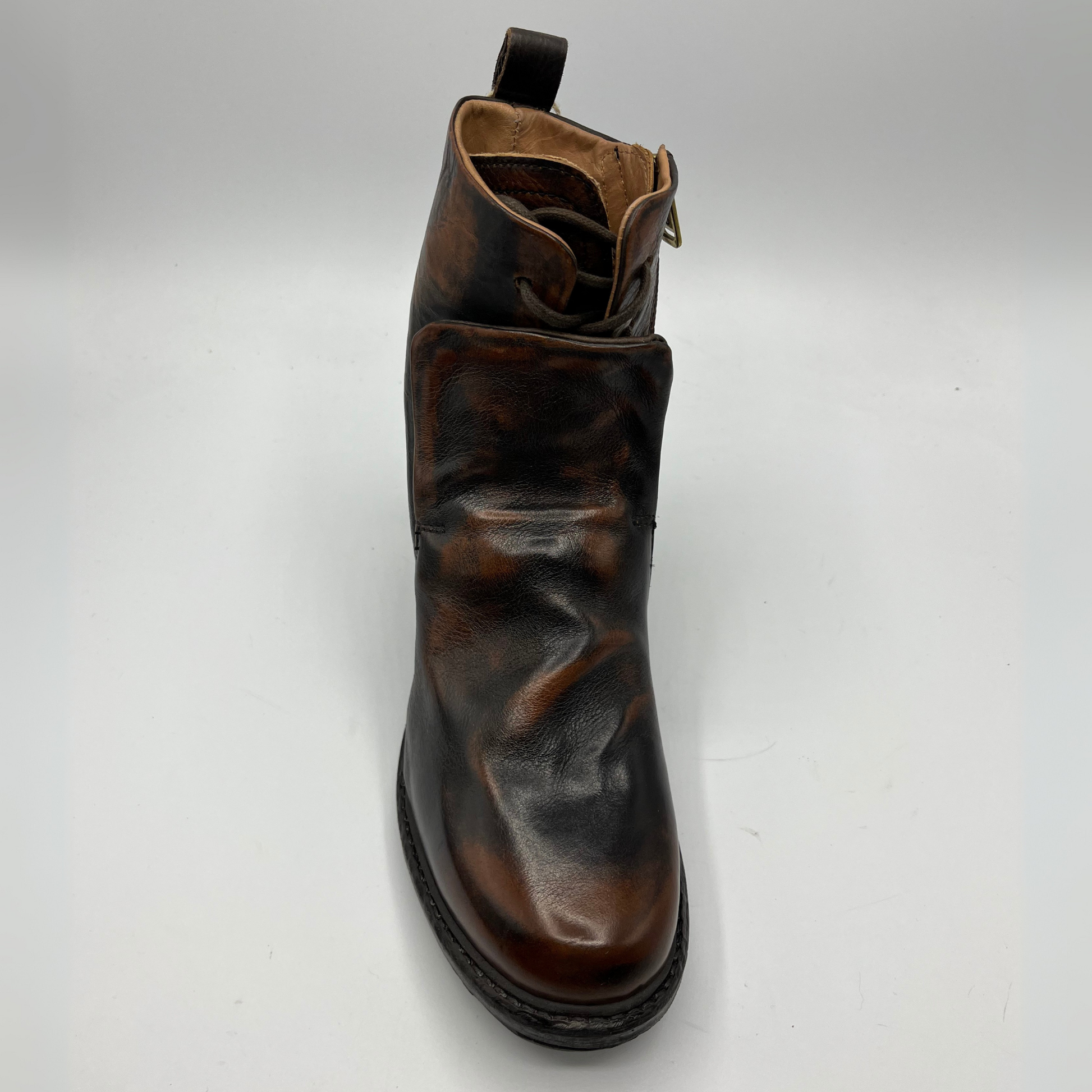 Top view of a brown and black burnished short boot with a gold accent on the heel and metallic embellishments along the shaft.