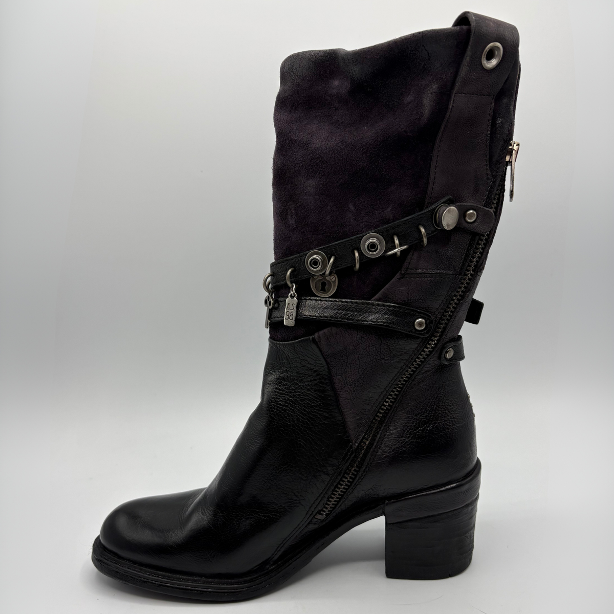 Left view of a black tall boot with a metal embellishments and a rubber outsole