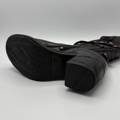 Bottom view of a black tall boot with a metal embellishments and a rubber outsole