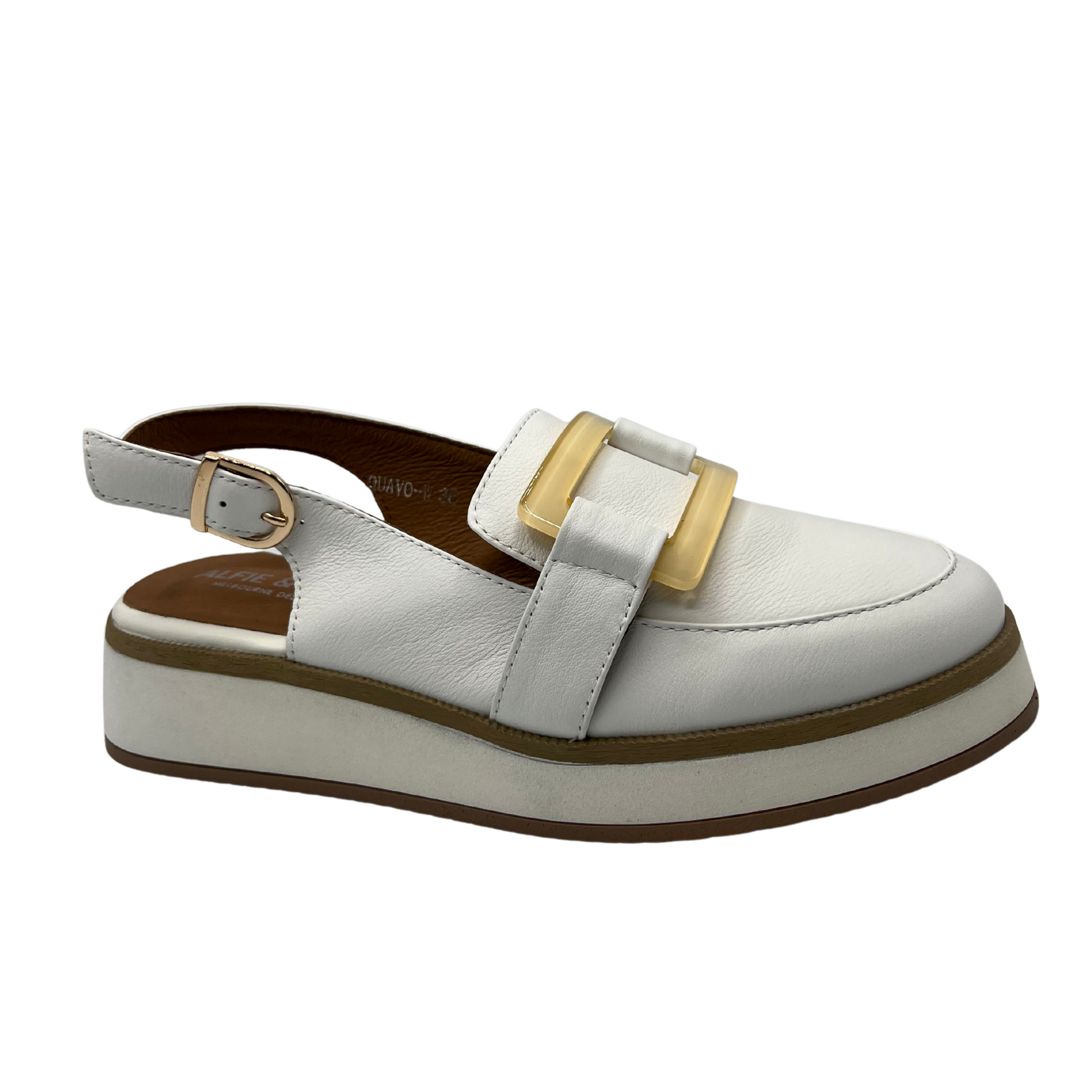 Angled view of white leather slip on loafer with adjustable sling back strap, opaque square gold detail on upper and white wedge outsole.