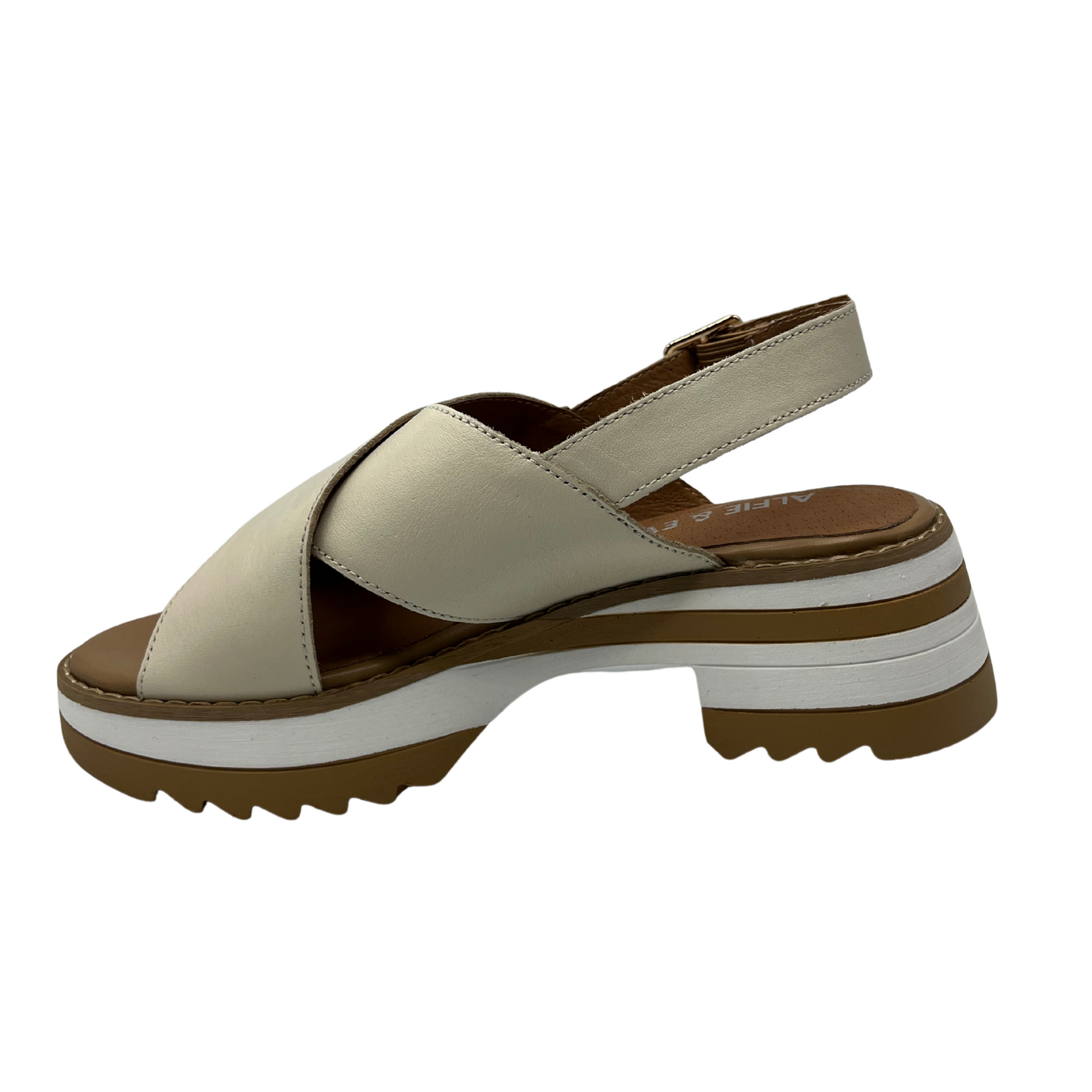 Left facing view of cream leather sandals with a cross strap design, chunky sole and adjustable sling back strap.