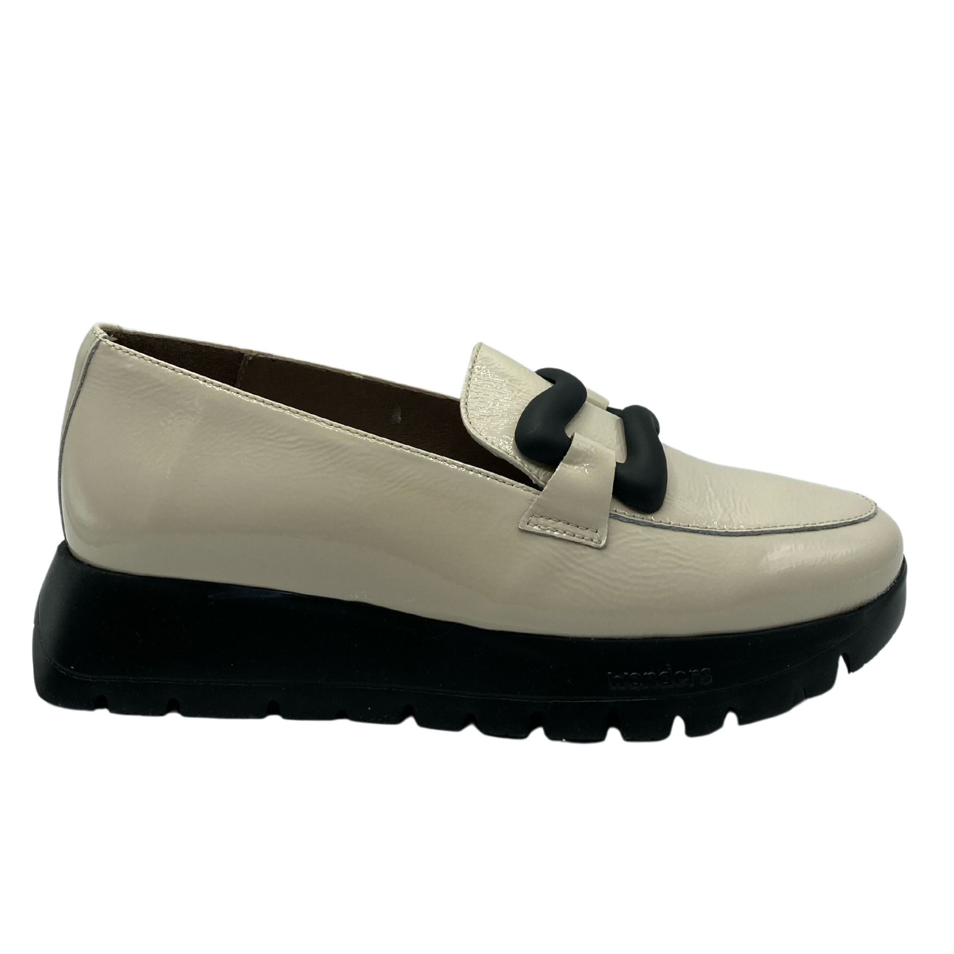View of the platform loafer from the side. Cream colour upper with black sole