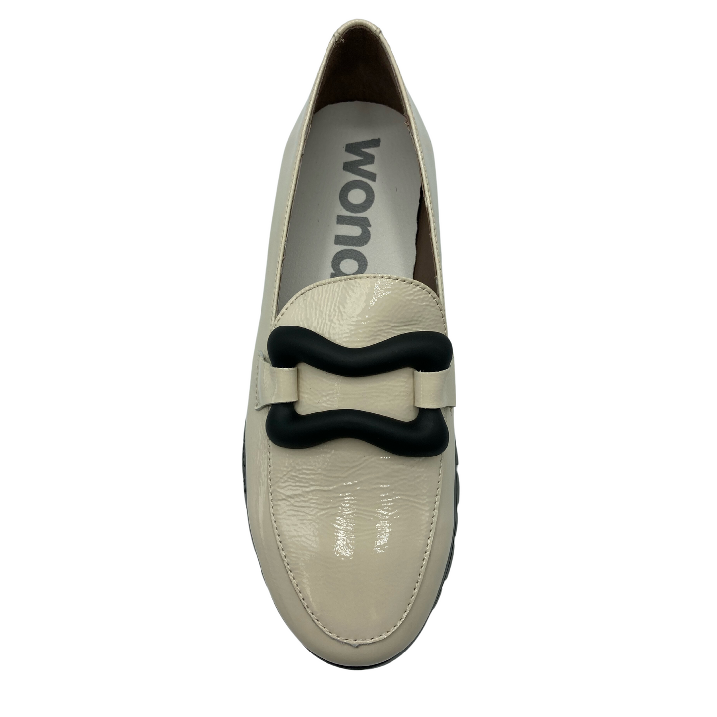 Top down view of milk coloured loafer with black buckle detail