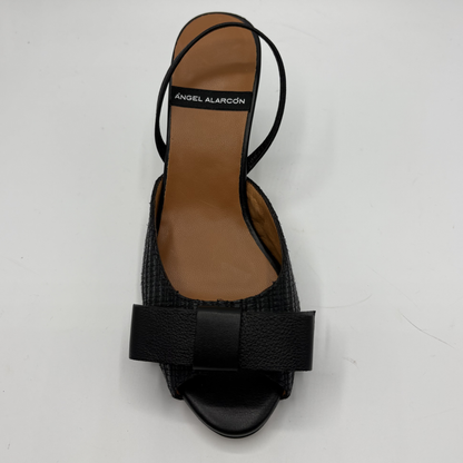 Black sandal with a bow on a white background