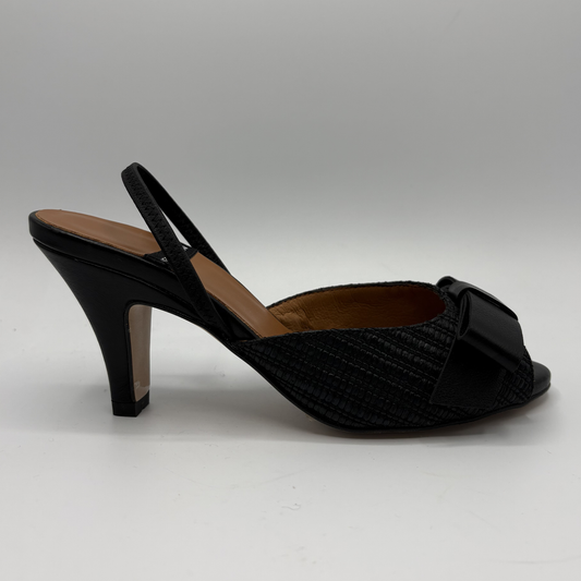 Black high-heeled shoe with a bow on a gray background