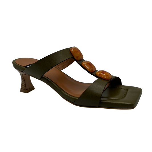 45 degree angled view of khaki leather sandal with square toe and square ornaments on upper. Flared heel and padded insole.