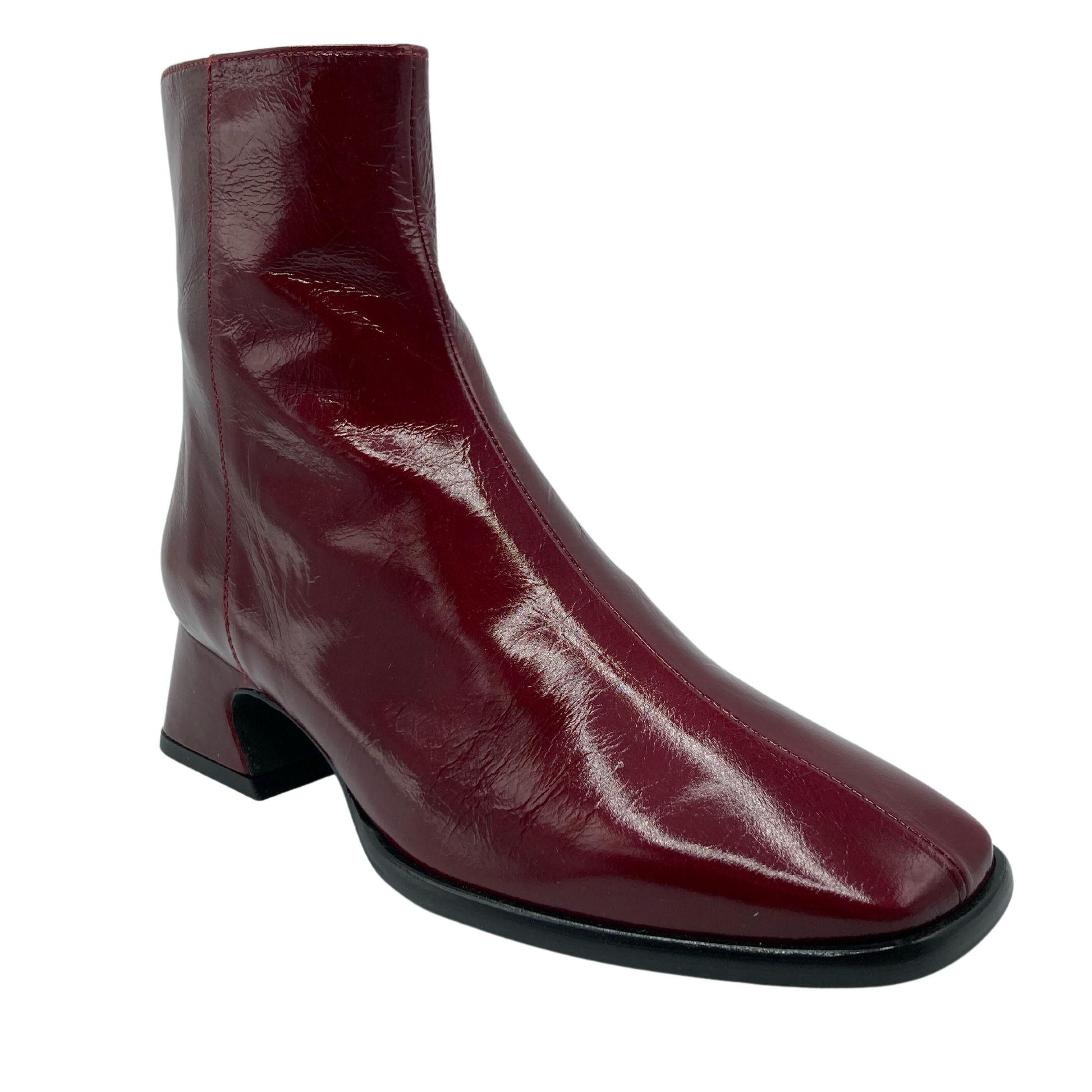 45 degree angled view of red leather boot with square toe and flared heel