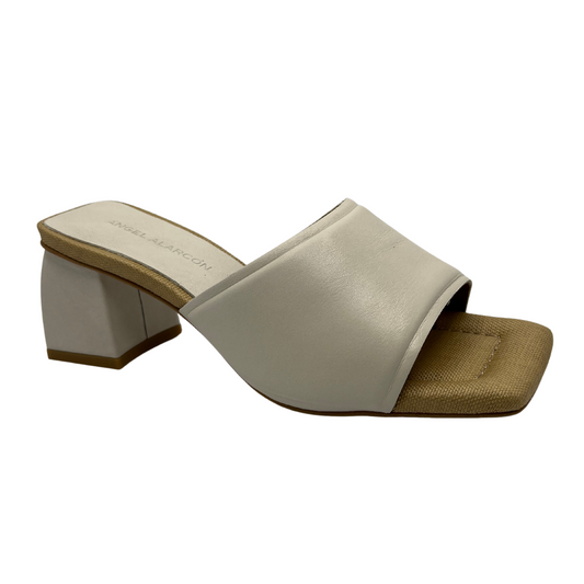 45 degree angled view of cream coloured leather slip on sandal with square toe, wrapped block heel and padded insole