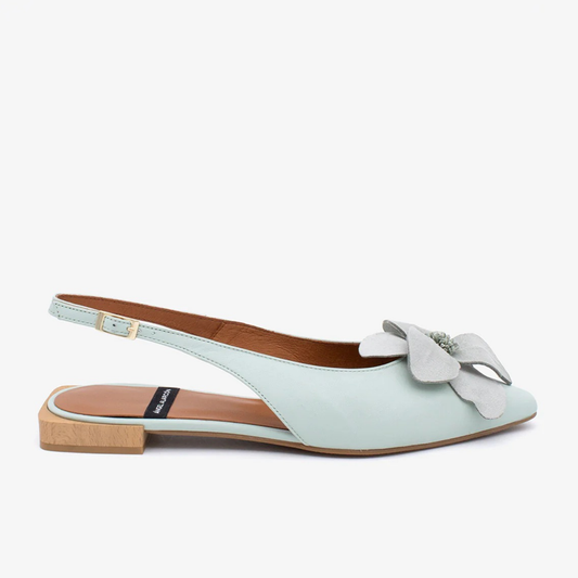 Light blue flat sandal with a bow on a white background