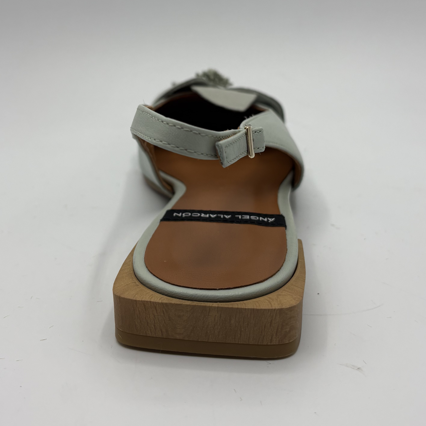 Sandal with wooden sole and gray strap on a white background