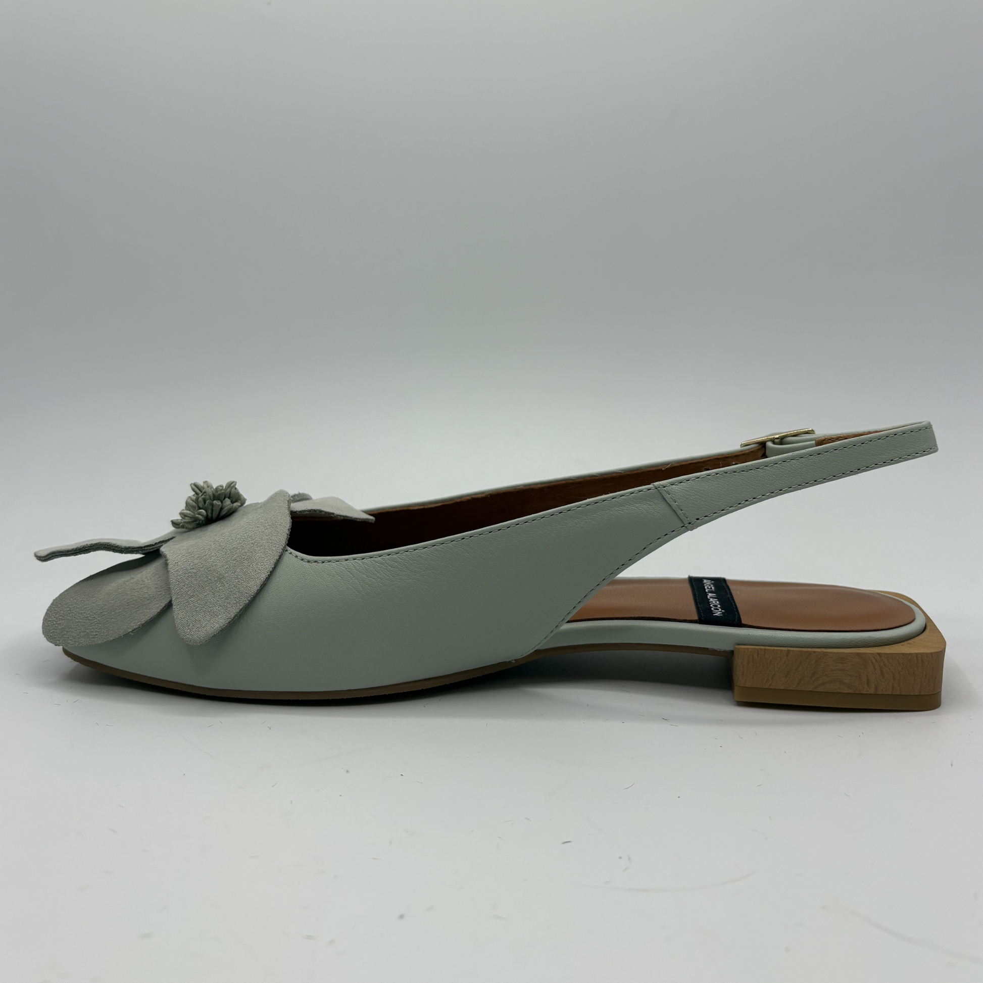 Light green slingback shoe with a bow on a white background