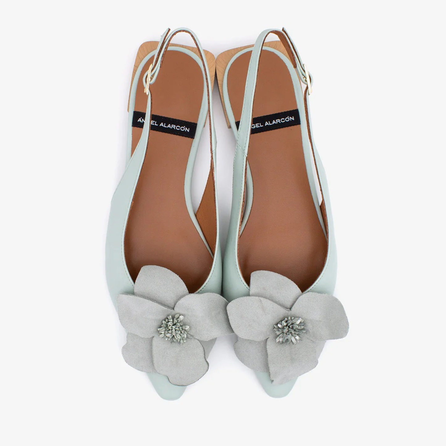 Light blue flats with gray floral embellishments on a white background