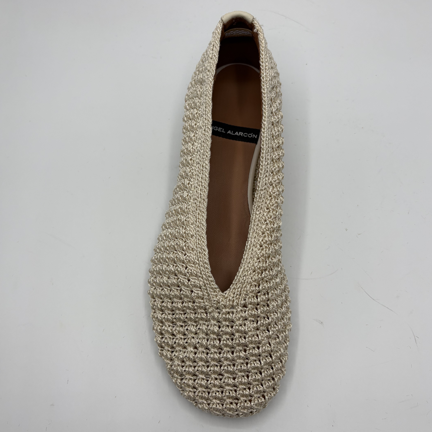 Beige crochet flat shoe on a white background