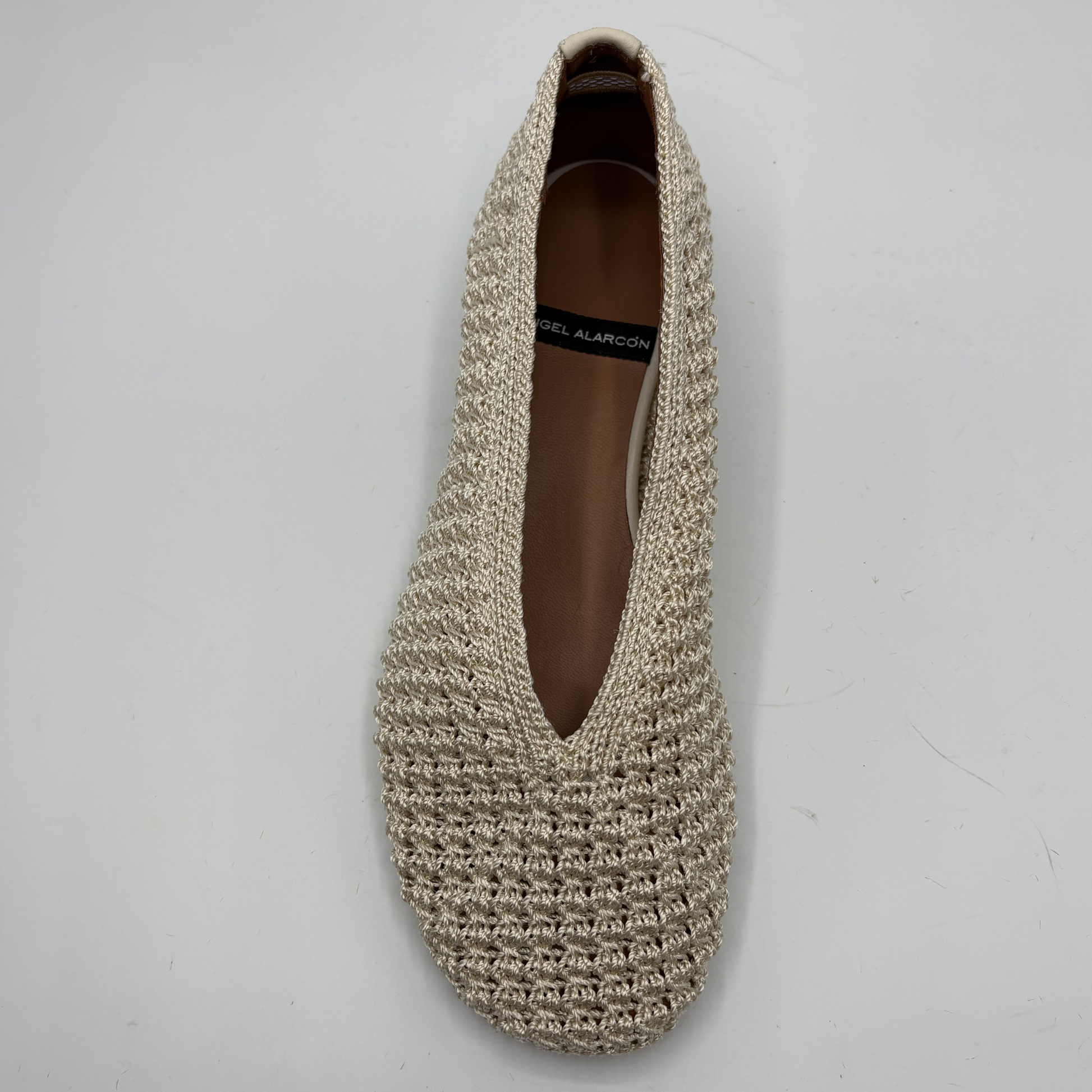 Beige crochet flat shoe on a white background
