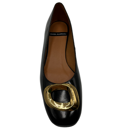 Top view of black patent leather ballet flat with 2.5cm heel, rounded toe and gold detail.