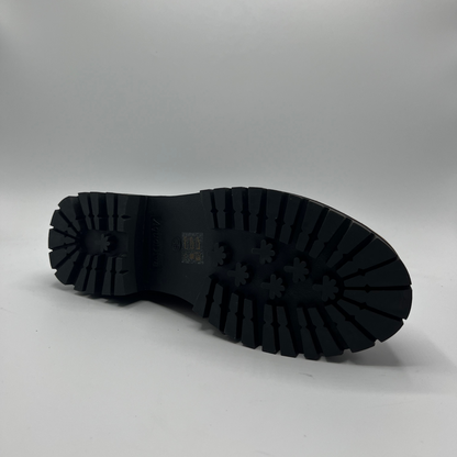 Black rubber sole of a shoe on a gray background