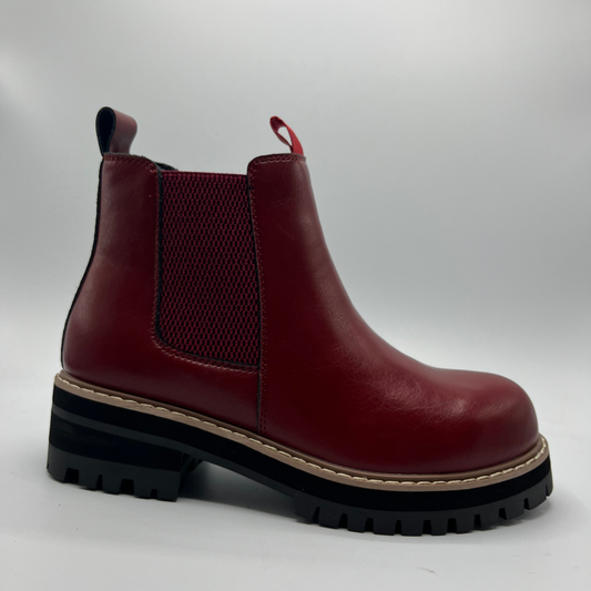 Red boot with a black sole on a white background
