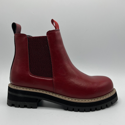 Red leather boot with a thick black sole on a white background